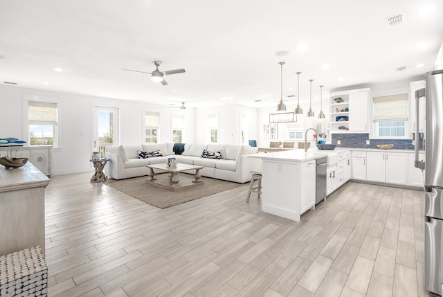 kitchen with a breakfast bar, white cabinetry, hanging light fixtures, kitchen peninsula, and stainless steel appliances