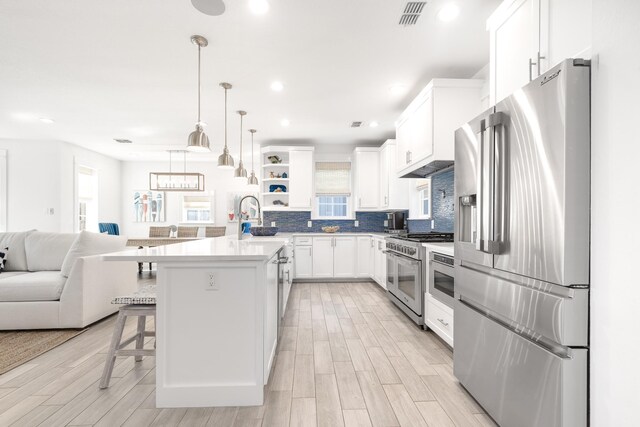 kitchen with a kitchen island, decorative light fixtures, white cabinetry, a kitchen bar, and high end appliances