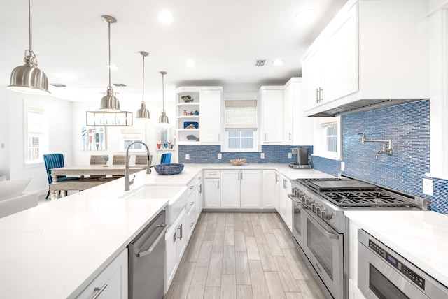 kitchen with pendant lighting, sink, white cabinets, and appliances with stainless steel finishes