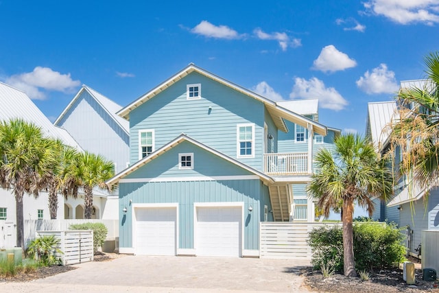 view of front of house with a balcony, a garage, and central AC unit