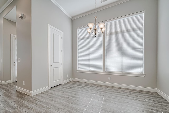 empty room with light hardwood / wood-style flooring, a notable chandelier, and crown molding