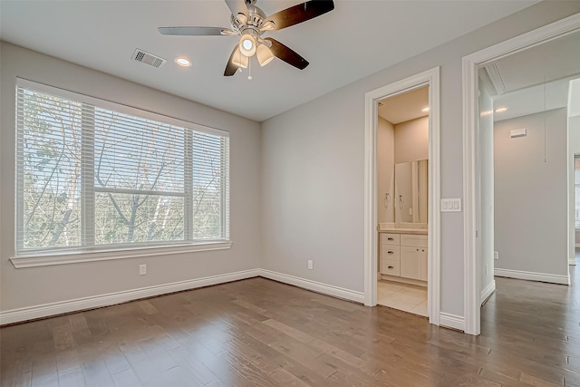 unfurnished bedroom with hardwood / wood-style floors, ensuite bath, and ceiling fan