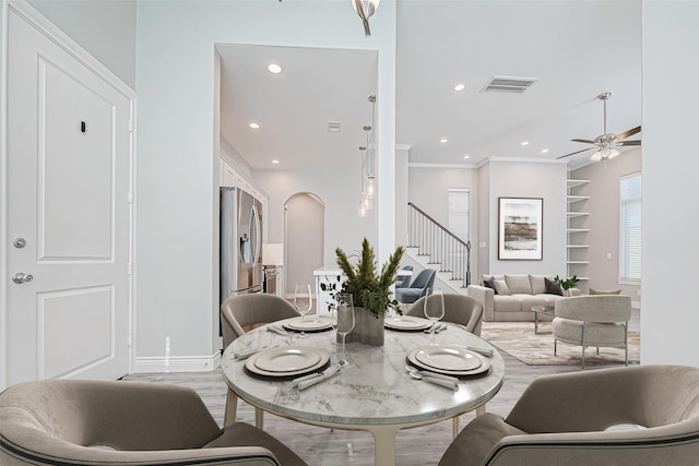 dining room with ceiling fan, crown molding, and light hardwood / wood-style floors