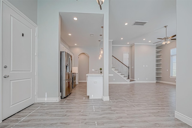 interior space featuring ceiling fan, light hardwood / wood-style floors, and crown molding