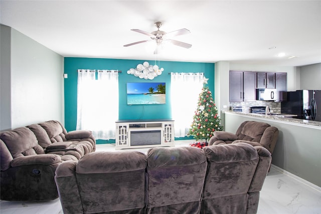 living room featuring ceiling fan and sink