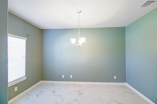 unfurnished room with an inviting chandelier