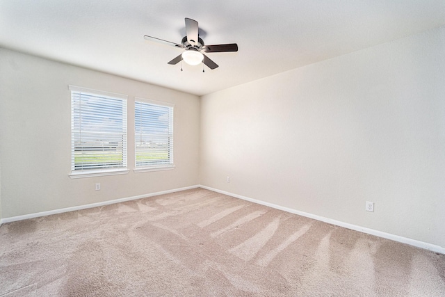 carpeted spare room featuring ceiling fan