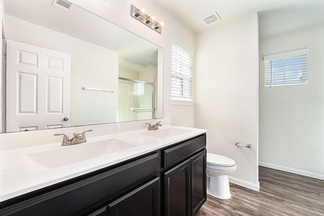 bathroom featuring a shower with door, hardwood / wood-style flooring, toilet, and vanity