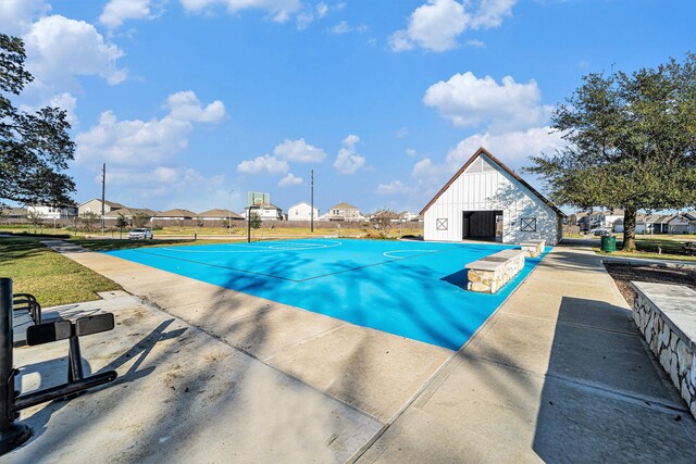 view of swimming pool with basketball hoop