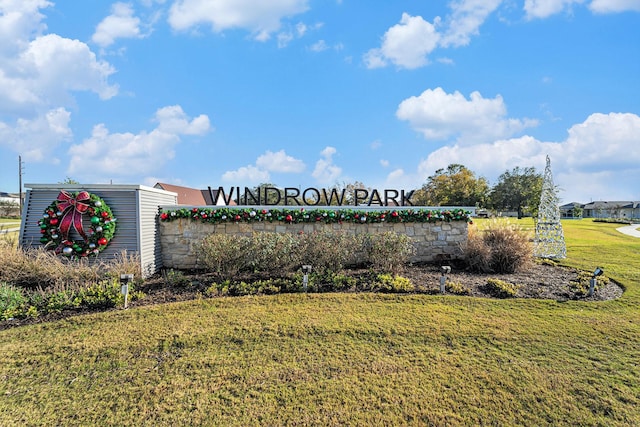 community / neighborhood sign with a yard