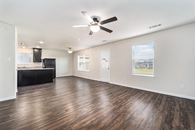 unfurnished living room featuring ceiling fan and dark hardwood / wood-style floors