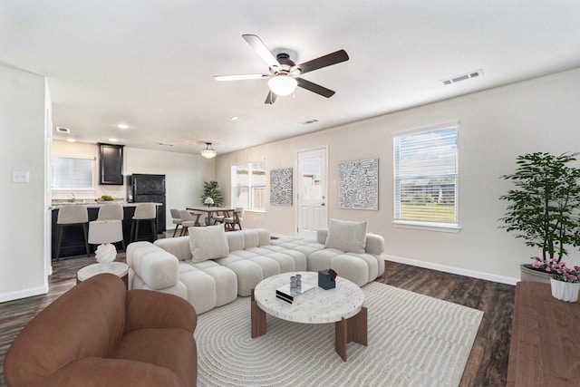 living room with ceiling fan and dark hardwood / wood-style flooring