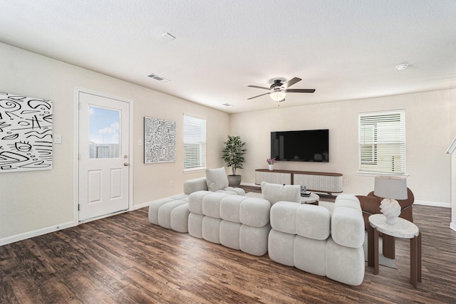 living room featuring ceiling fan and dark hardwood / wood-style floors