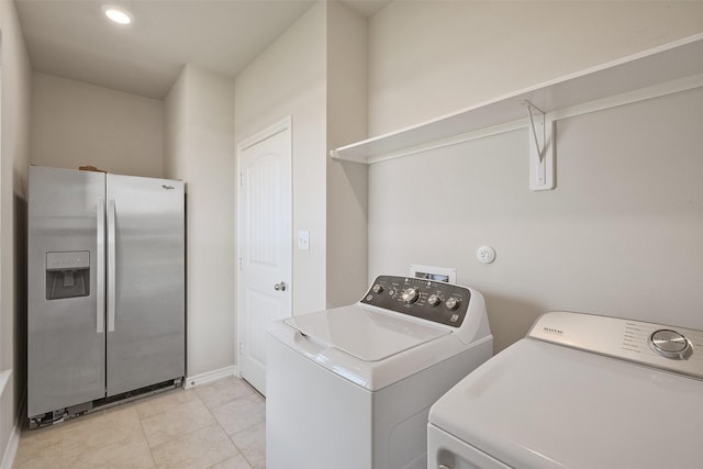 laundry room featuring washing machine and dryer and light tile patterned floors