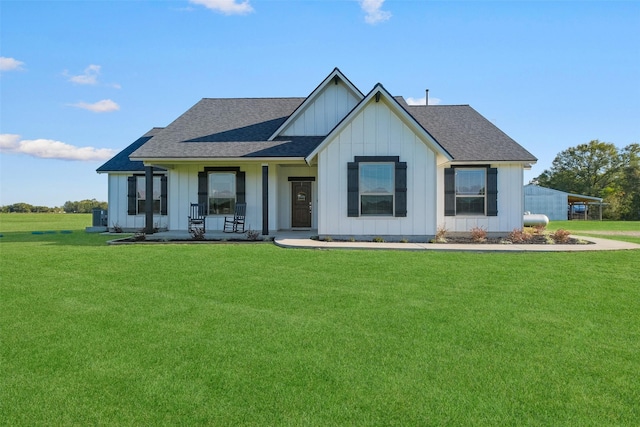 modern farmhouse featuring covered porch and a front yard