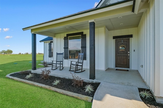 property entrance featuring a yard and covered porch