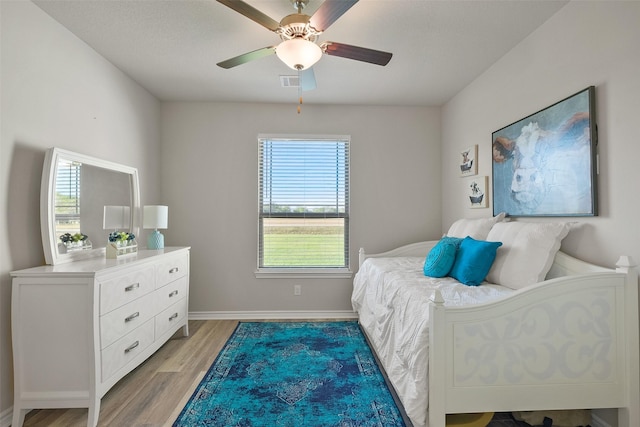 bedroom with multiple windows, ceiling fan, and light wood-type flooring