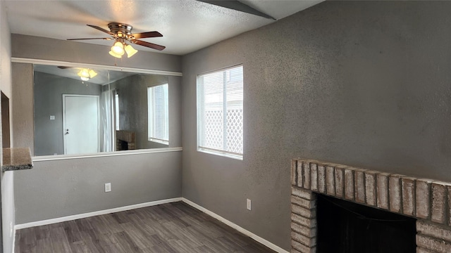 interior space with ceiling fan, dark hardwood / wood-style floors, and a brick fireplace