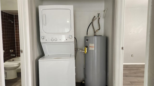 laundry room with light hardwood / wood-style floors, stacked washer and clothes dryer, and water heater