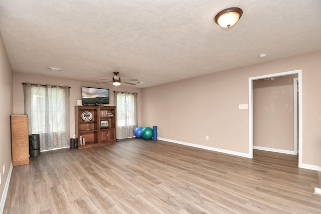 unfurnished living room with hardwood / wood-style floors, a textured ceiling, a wealth of natural light, and ceiling fan