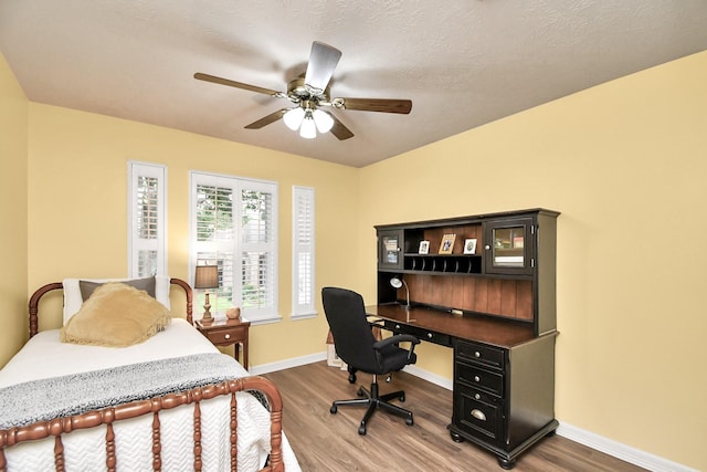 bedroom featuring hardwood / wood-style flooring, ceiling fan, and a textured ceiling