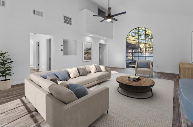 living room with ceiling fan, high vaulted ceiling, and wood-type flooring