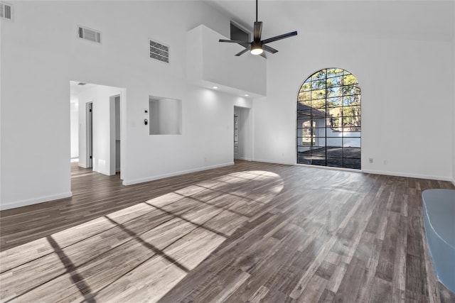 unfurnished living room featuring ceiling fan, dark wood-type flooring, and high vaulted ceiling