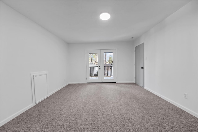 carpeted spare room featuring french doors