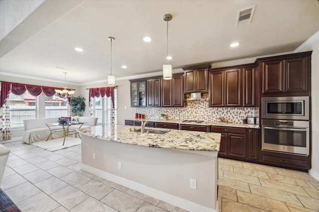 kitchen featuring pendant lighting, tasteful backsplash, appliances with stainless steel finishes, ornamental molding, and sink