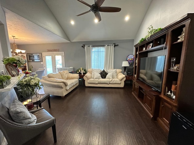 living room featuring dark hardwood / wood-style floors, ceiling fan with notable chandelier, and high vaulted ceiling