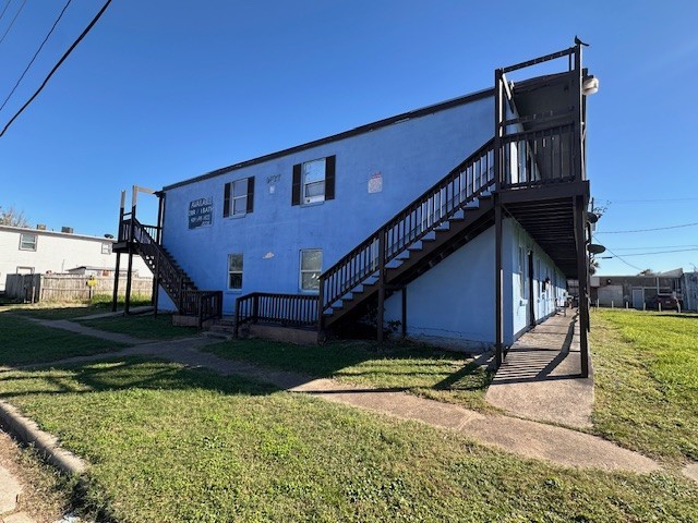 rear view of property with a lawn