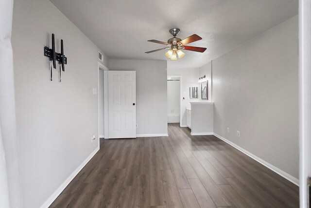 unfurnished living room featuring ceiling fan and dark hardwood / wood-style flooring