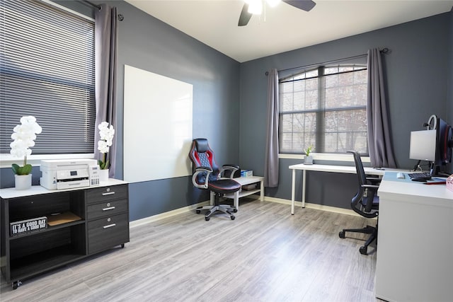 office with light wood-type flooring and ceiling fan