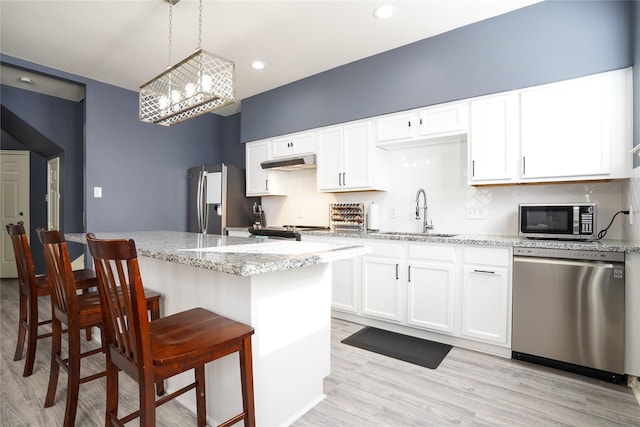 kitchen with light wood-type flooring, stainless steel appliances, white cabinetry, and sink