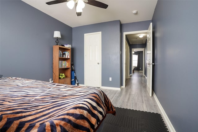 bedroom featuring ceiling fan, light hardwood / wood-style floors, and vaulted ceiling