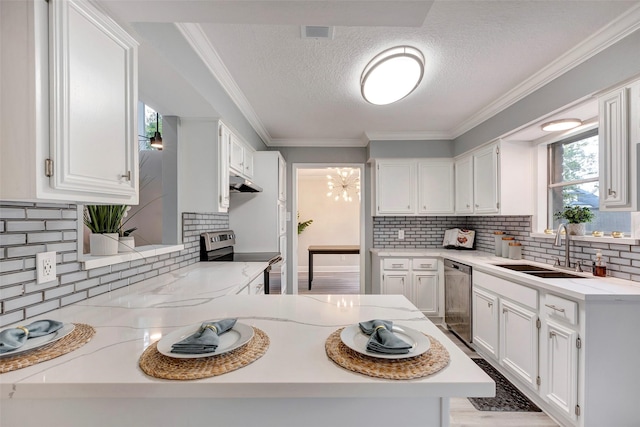 kitchen with backsplash, kitchen peninsula, sink, white cabinetry, and stainless steel appliances