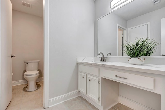 bathroom featuring toilet, vanity, and tile patterned flooring