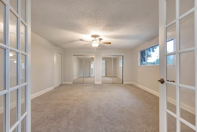 unfurnished room featuring ceiling fan, french doors, carpet floors, and a textured ceiling