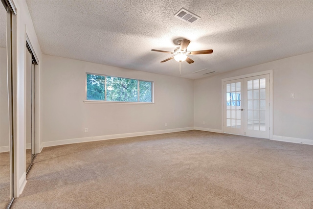 unfurnished bedroom with ceiling fan, french doors, light carpet, and a textured ceiling