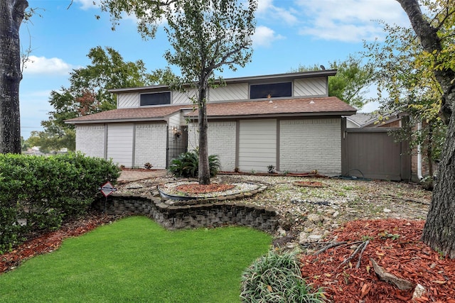 rear view of property featuring a lawn