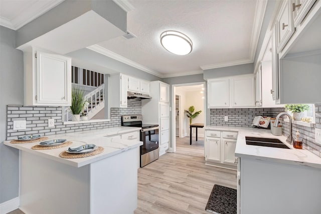 kitchen with electric stove, kitchen peninsula, sink, a textured ceiling, and white cabinets