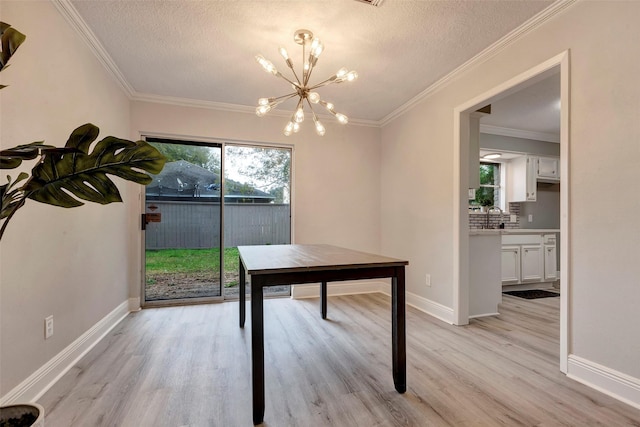 home office featuring a textured ceiling, crown molding, a chandelier, and light hardwood / wood-style flooring