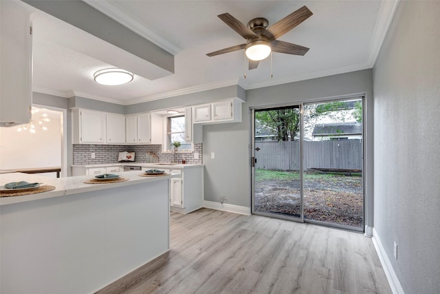 kitchen with white cabinetry, decorative backsplash, ceiling fan, light hardwood / wood-style flooring, and crown molding