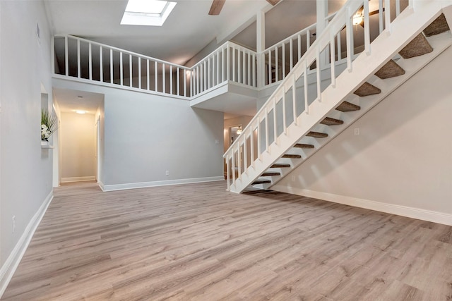 unfurnished living room with wood-type flooring and a high ceiling