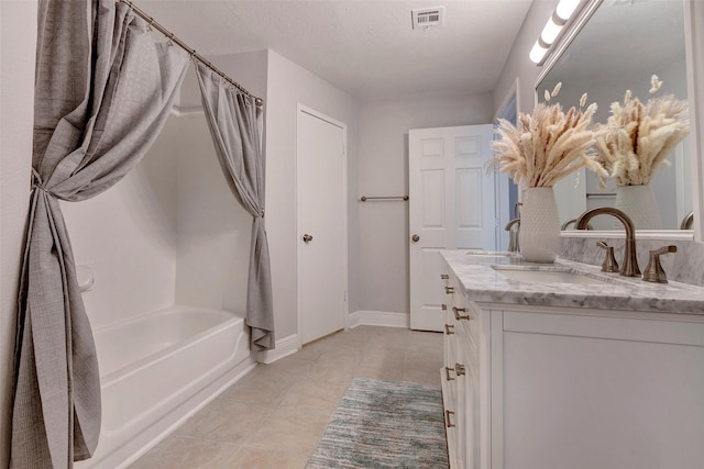 bathroom with vanity, tile patterned flooring, a washtub, and a textured ceiling