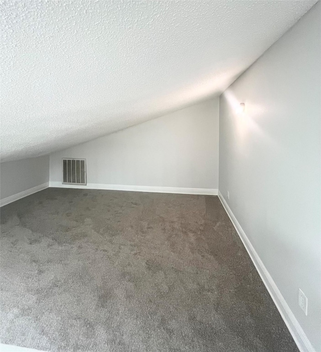 bonus room featuring a textured ceiling, carpet, and vaulted ceiling