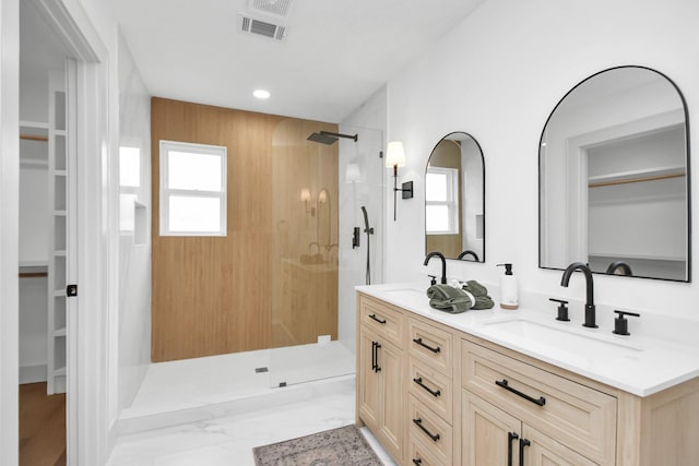 bathroom featuring walk in shower, vanity, and a healthy amount of sunlight