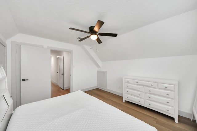 bedroom with vaulted ceiling, ceiling fan, and wood-type flooring