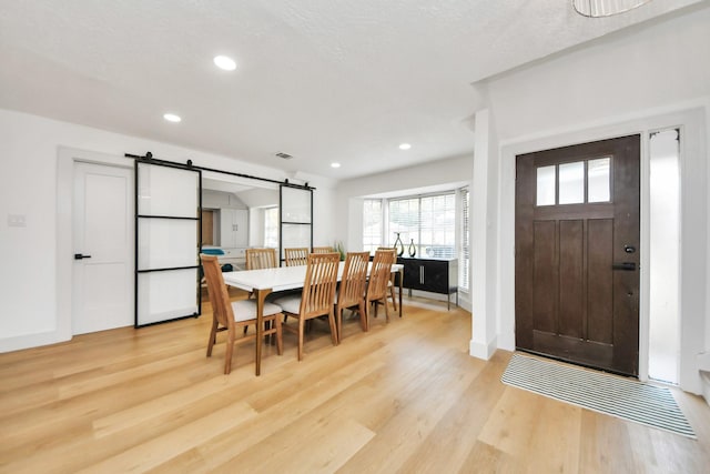 dining room featuring light hardwood / wood-style floors and a barn door