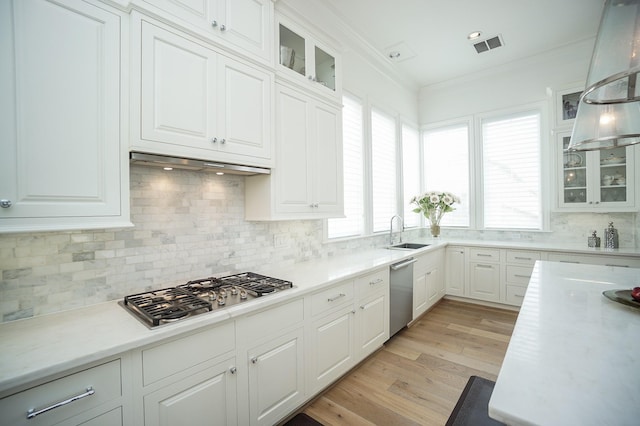 kitchen with white cabinetry, crown molding, pendant lighting, appliances with stainless steel finishes, and light wood-type flooring